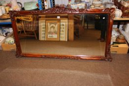 Carved mahogany framed bevelled overmantel mirror, 76cm by 145cm.