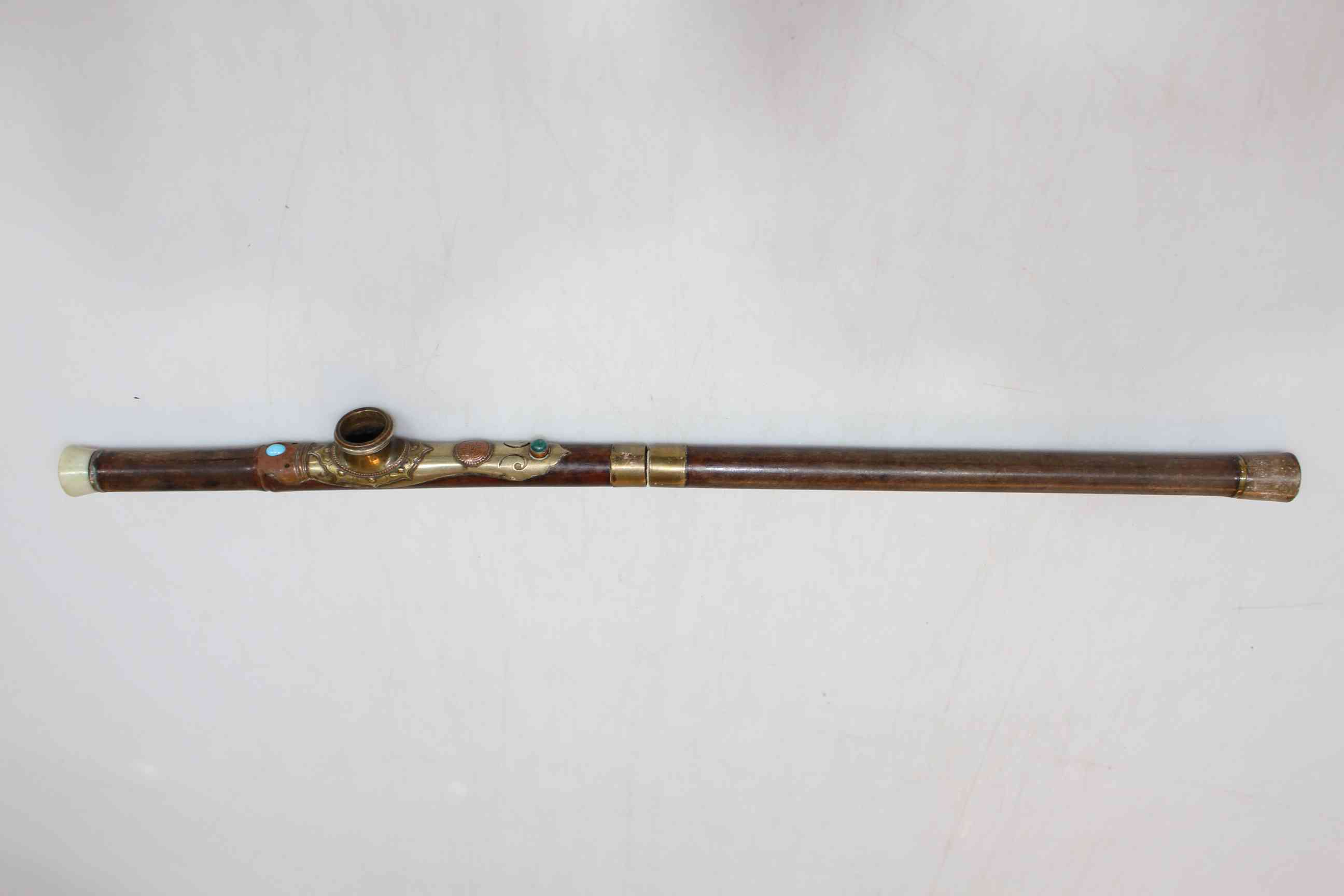 Opium pipe with jewelled brass mount, 48cm length.