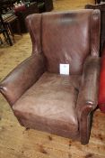 Brown leather wing armchair.