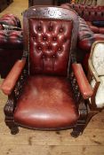 Victorian buttoned leather library chair on turned legs.