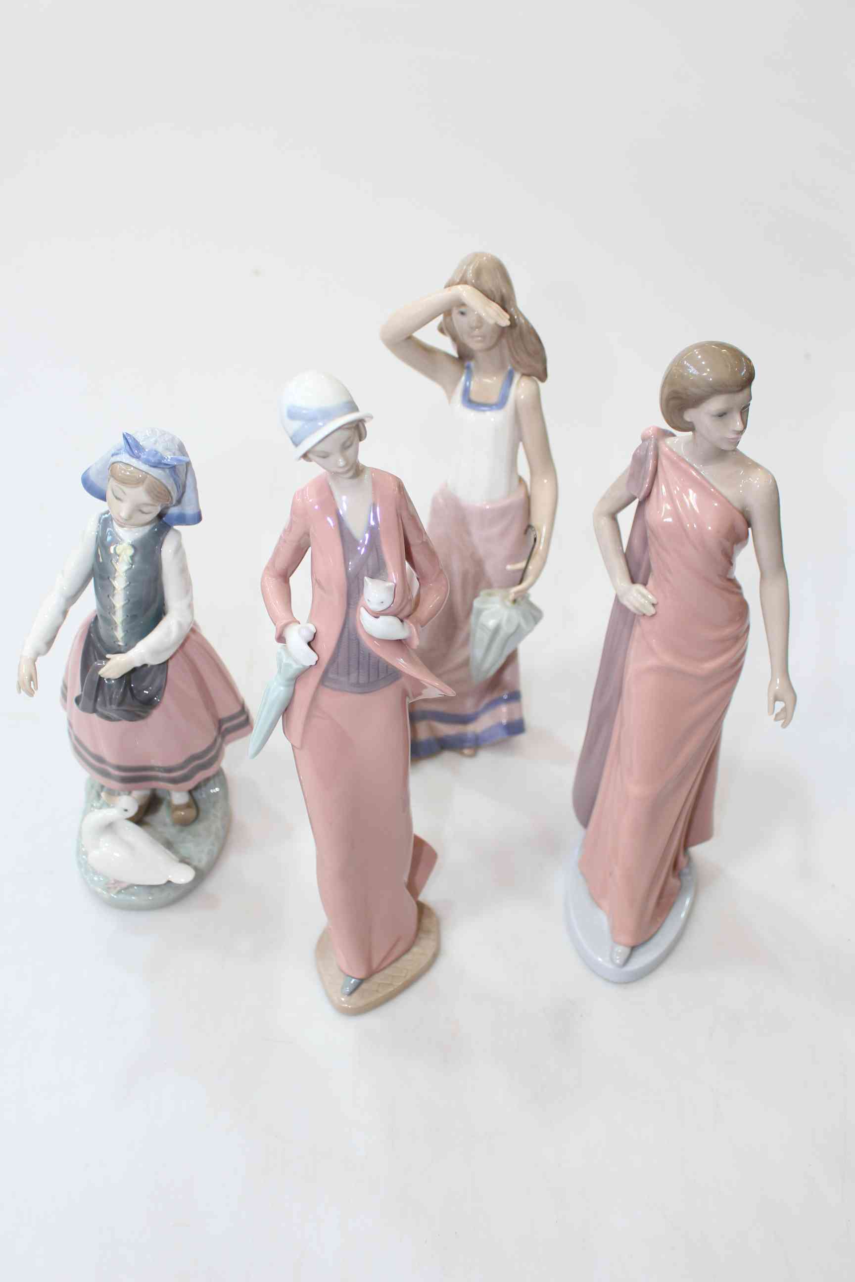 Lladro Goose Girl and three Nao figurines (4).