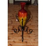 Large, probably Linthorpe pottery vase in wrought iron stand, overall height 89cm.