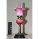 Victorian oil lamp with opaque ruby glass reservoir and fluted shade, 43cm to top of shade.