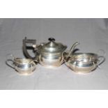 Silver three piece tea set of lobed oval form engraved with garland, Birmingham 1911.