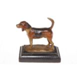 Cold painted metal figure of hound on wood plinth base, 15cm high.