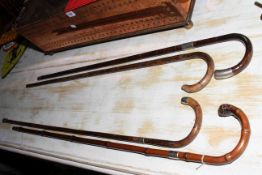 Four walking canes including three silver collared.