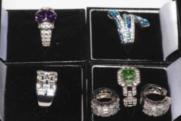 Four boxed fancy gem set silver rings, and pair of earrings.