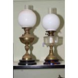 Two brass oil lamps with opaque glass shades.