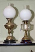 Two brass oil lamps with opaque glass shades.