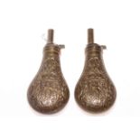 Two embossed brass powder flasks.