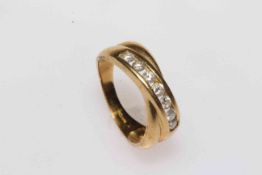 18 carat gold crossover design ring set with row of seven diamonds, size O/P.