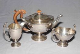 Elegant silver three piece tea set of pedestal form, teapot Birmingham 1911, sugar and cream 1915.
