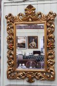 Ornate gilt framed bevelled wall mirror, 124cm x 84cm overall.