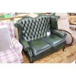 Bottle green buttoned leather wing back two seater settee.