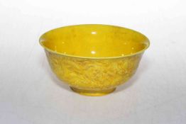 Chinese yellow glazed bowl, having relief dragon decoration, marks to base, 15.5cm diameter.