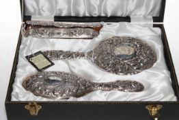 Cased silver embossed four piece brush and mirror set.