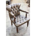 Buttoned leather library chair on reeded legs in coffee leather.
