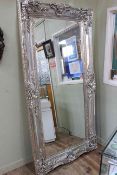 Rectangular ornate silvered framed bevelled wall mirror, 203cm by 102cm.