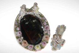 Continental porcelain boudoir mirror encrusted with flowers and with cherubs, 33cm by 26cm,