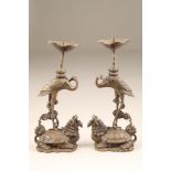 Pair 20th century Chinese bronze candle sticks. Storks standing on mythical creatures. 26cm high.