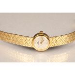 Bucherer ladies 18 carat gold wrist watch, silver dial with hour markers on 18 carat gold strap.