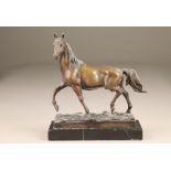 A bronze horse on a black marble base, 29cm high.