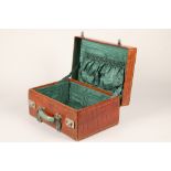 A fine crocodile leather suitcase, with an outer protective cover and green lining. 46cm long,
