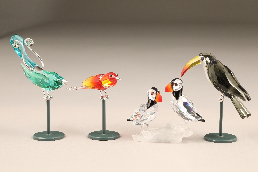 Four assorted Swarovski coloured glass birds, with stands and original boxes.