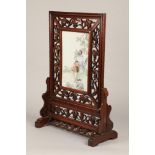 20th century Chinese carved hardwood screen with a porcelain figure panel, pierced frame