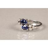 Tanzanite and diamond ring, set in a white metal shank. Two central oval cut tanzanites flanked by