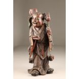 18th/19th century Chinese carved and painted figure of a Buddhist carrying a large lotus flower,