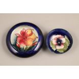 Two Moorcroft pottery trinket dishes, one decorated in pansy design on blue ground, incised