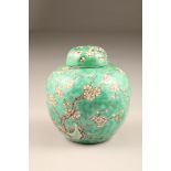 19th/20th century Chinese ginger jar and cover, green ground decorated with birds in a flowering