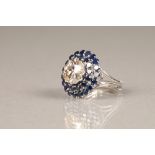 A diamond and sapphire three tiered circular cluster ring, centrally set with brilliant cut