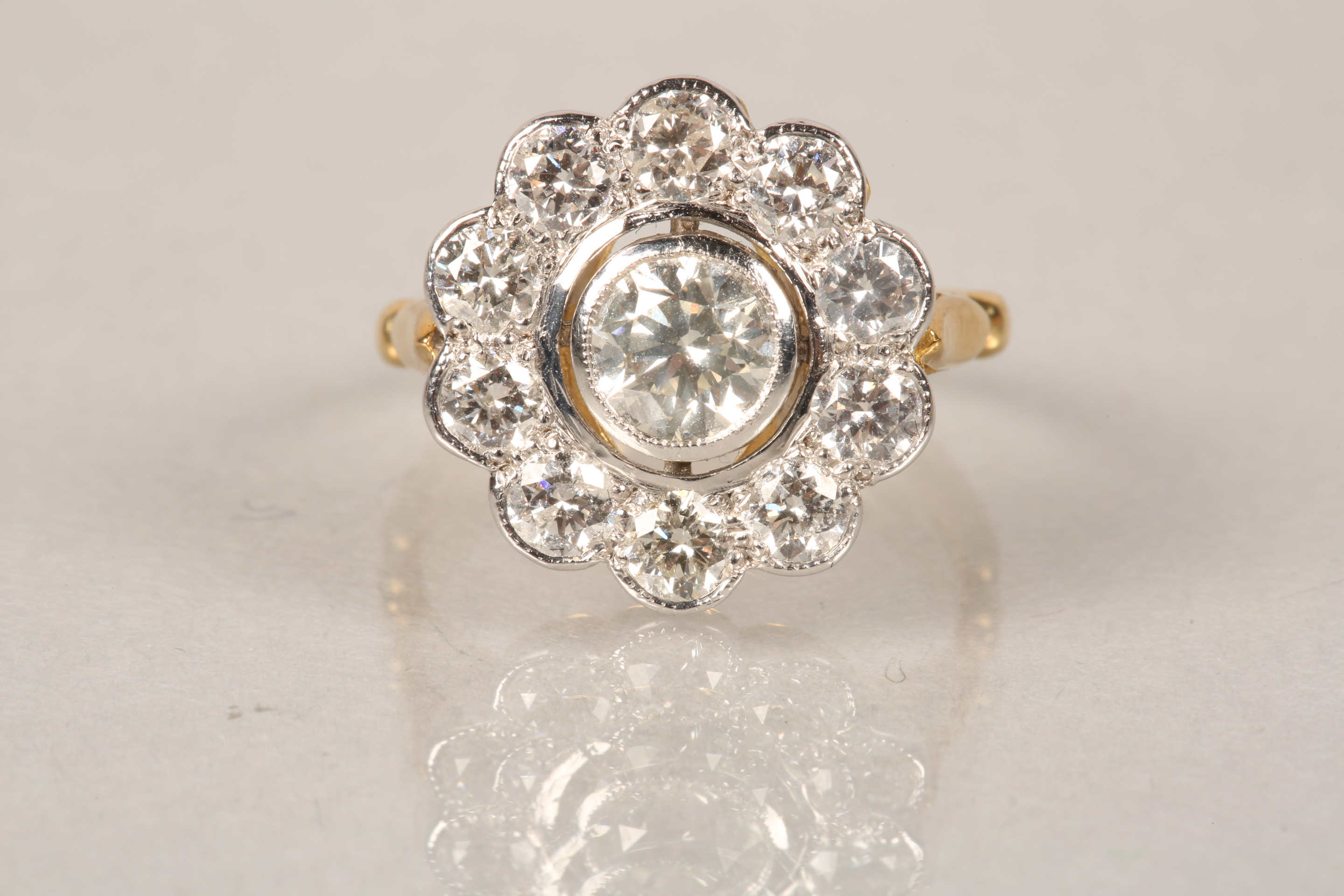 18 carat gold diamond cluster ring, daisy form, centre stone approx. 0.75 carat brilliant cut