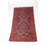 Persian rug, black border with geometric patterns in red, blue, green and white, 84cm wide, 150cm