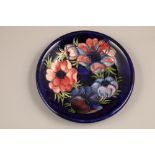 Moorcroft pottery dish, decorated in anemone design, on blue ground, signed William Moorcroft,