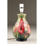 Moorcroft pottery table lamp, green ground with orchid pattern. Lamp base only, 25cm high.