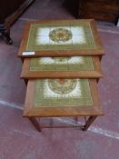 A teak nest of tiled topped tables