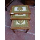 A teak nest of tiled topped tables