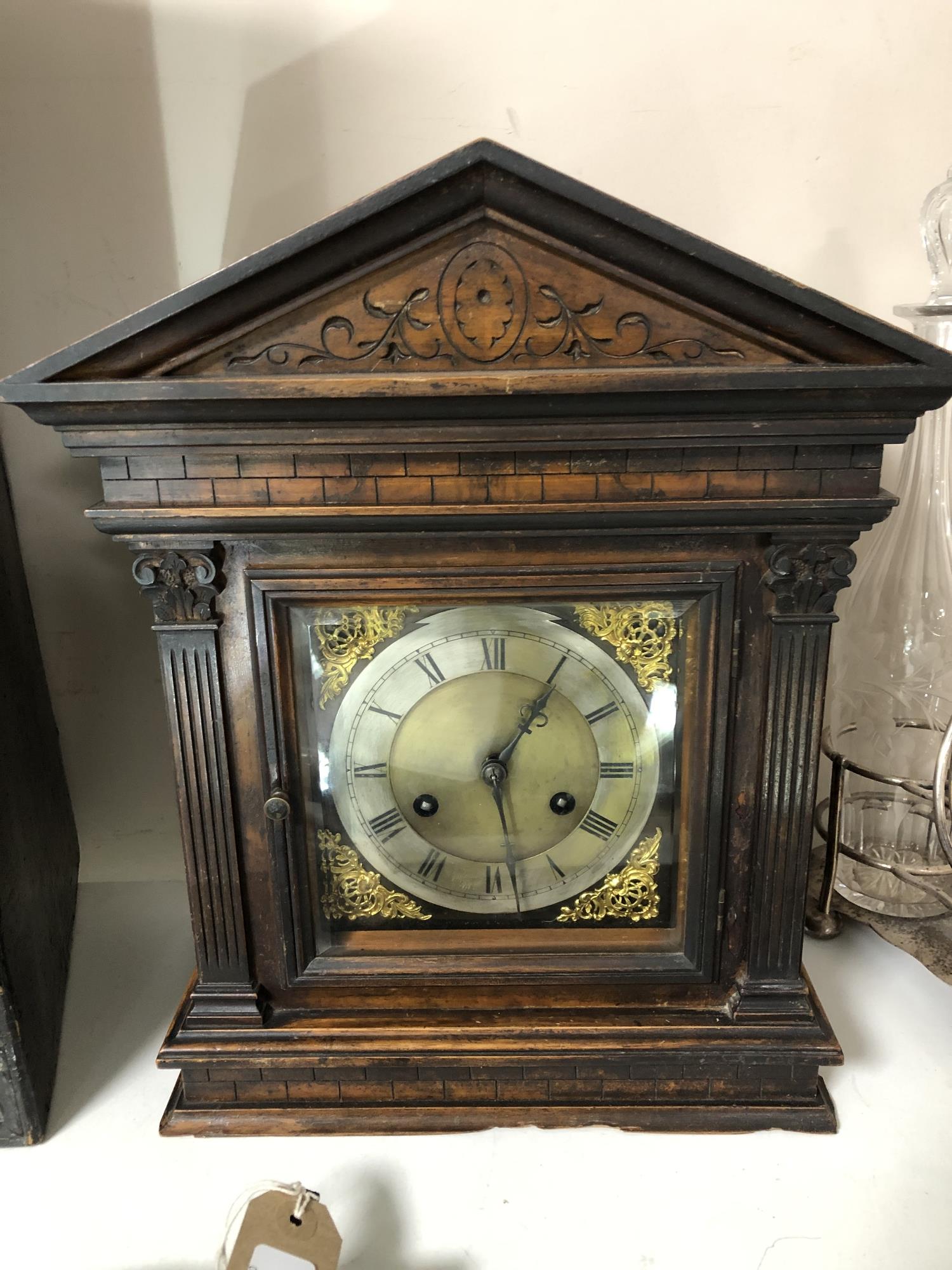 An Edwardian carved pine cased bracket clock with brass and enamelled dial