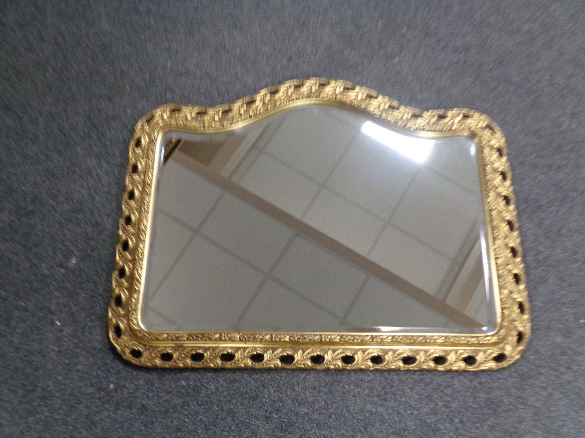 A shaped gilt framed bevelled mirror