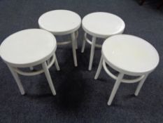 A set of four white plastic Ikea stools