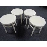 A set of four white plastic Ikea stools