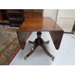 An inlaid mahogany pedestal flap sided dining table