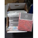 A box of new bedding including linen bed spread, quilt,