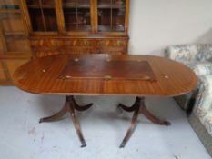 A mahogany twin pedestal extending dining table with leaf