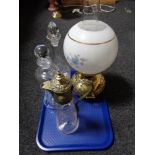A brass and glass oil lamp together with claret jug and decanters