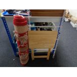 A red Chinese fringed rug, clothes airer and a folding table.