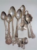 A collection of silver and white metal spoons,